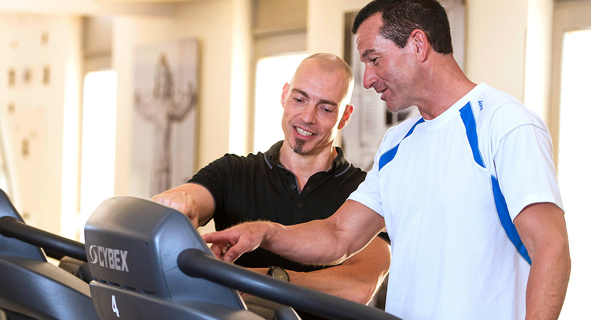 Personal Trainer Guido Halver erklärt seinem Kunden das Laufband