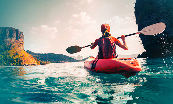 Kanufahrerin paddelt auf einem Fluss Kanufahrerin paddelt alleine auf einem Fluss